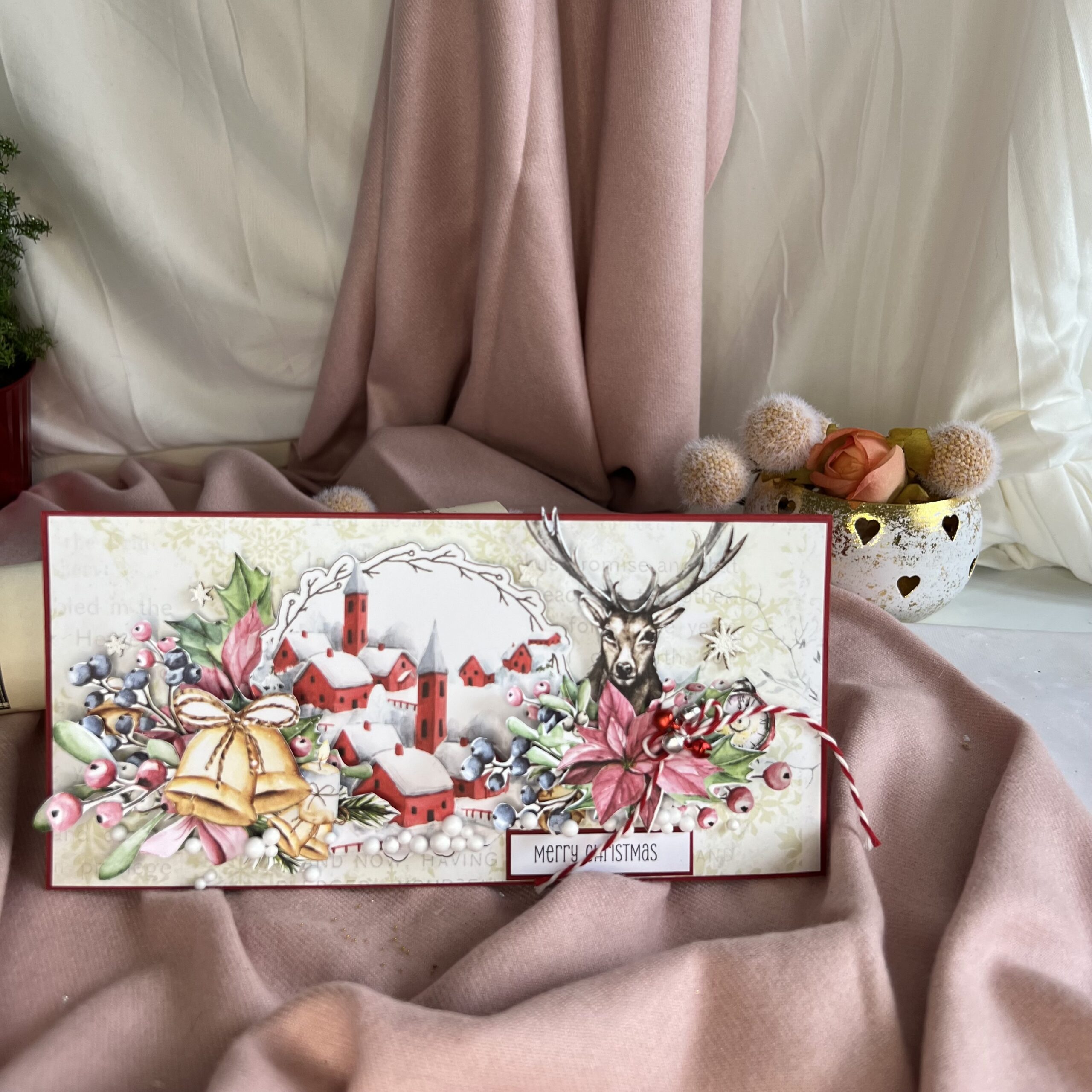 Close-up of reindeer and winter village detail on handmade Christmas card