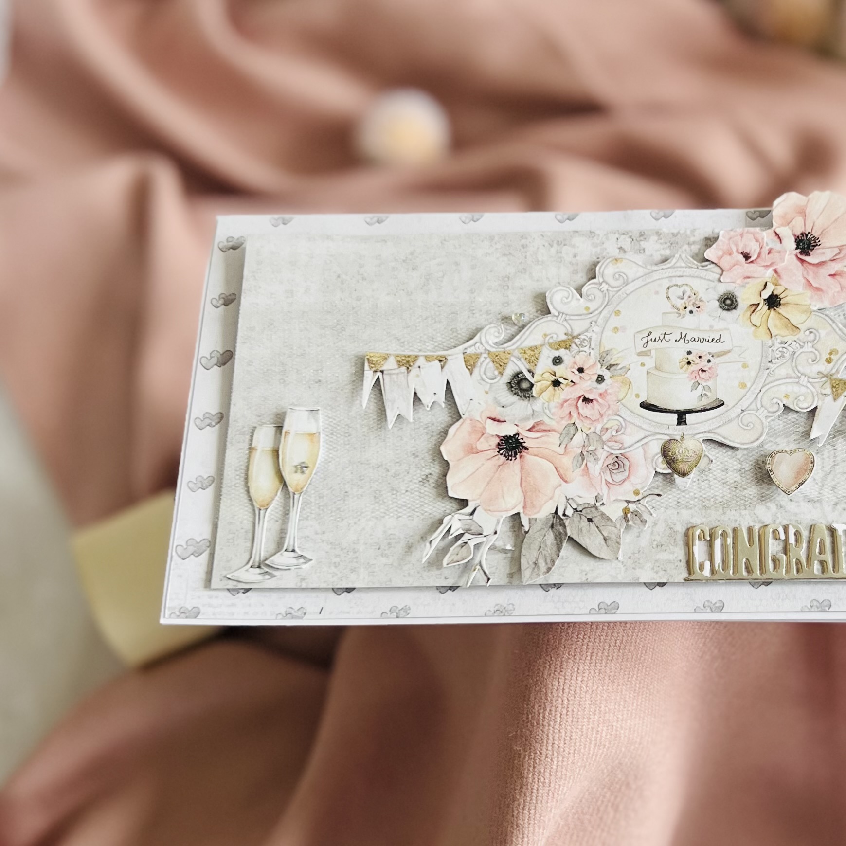 Close-up of champage glasses and paper flowrs on a handmade wedding card